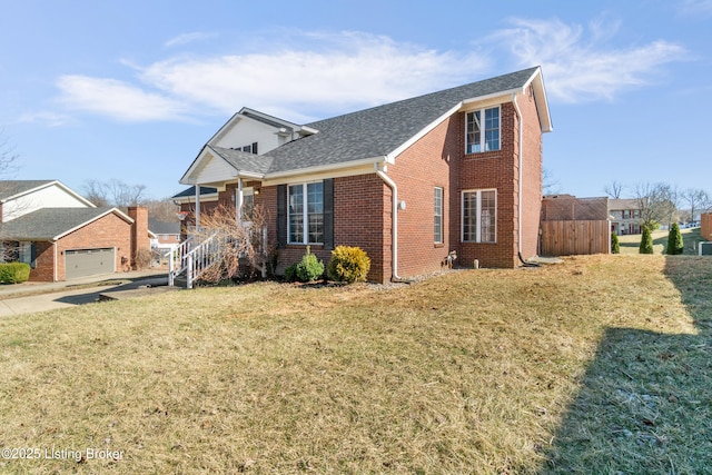 view of front of home with a garage, brick siding, roof with shingles, and a front yard