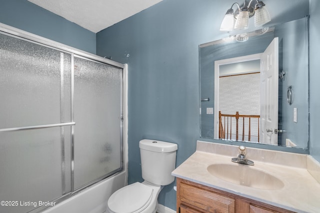 bathroom with toilet, bath / shower combo with glass door, and vanity