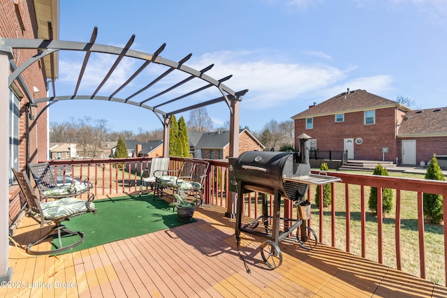 wooden deck featuring a grill, a residential view, and a pergola