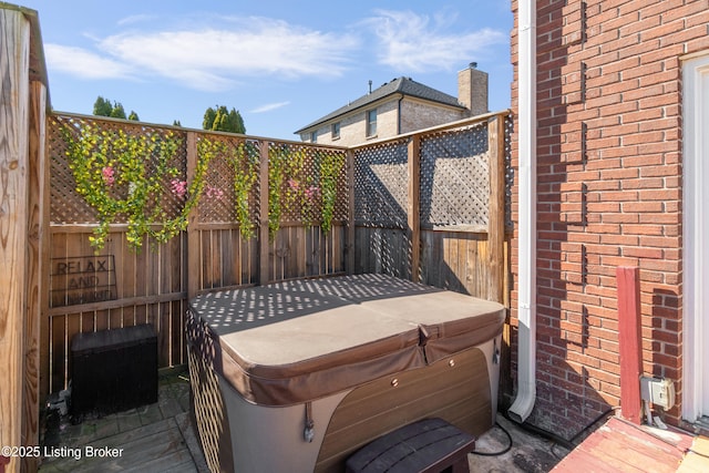 wooden terrace with fence and a hot tub