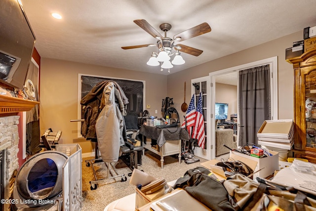 misc room featuring a ceiling fan, carpet, and a fireplace