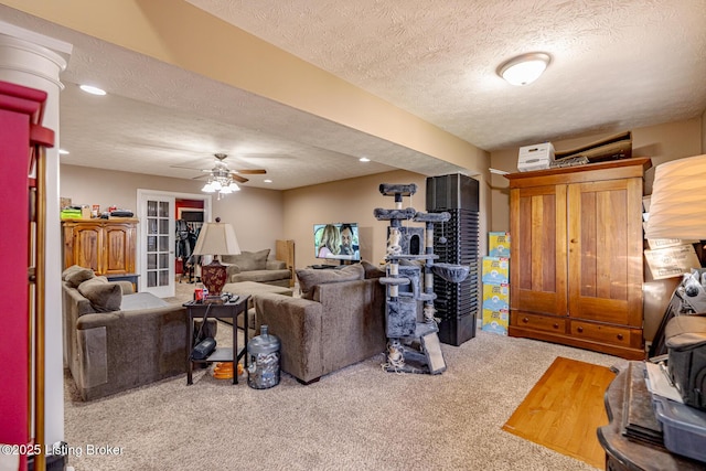 carpeted living area with a ceiling fan, recessed lighting, a textured ceiling, and ornate columns