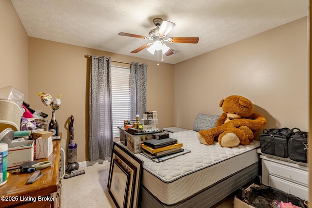 bedroom with light carpet, ceiling fan, baseboards, and a textured ceiling