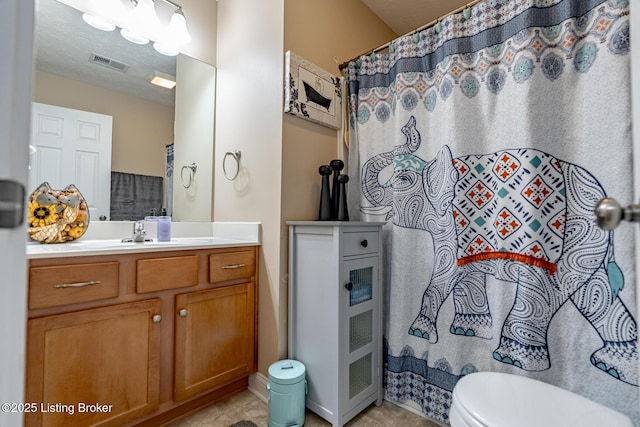 bathroom featuring toilet, vanity, visible vents, and a shower with curtain