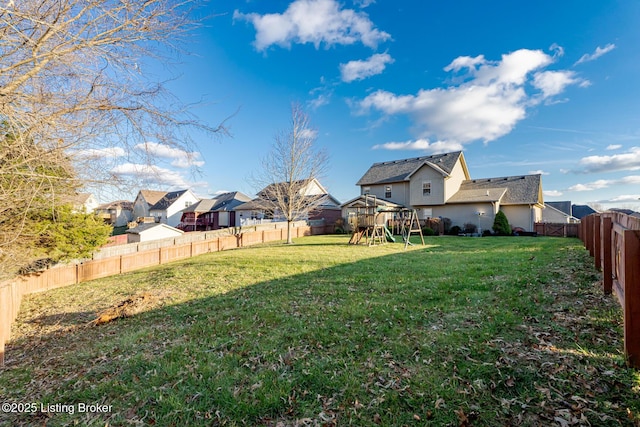 view of yard featuring a fenced backyard, a residential view, and a playground