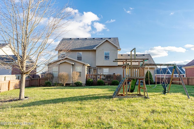 back of house with a yard, a playground, fence, and roof with shingles