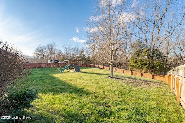 view of yard with a playground and a fenced backyard