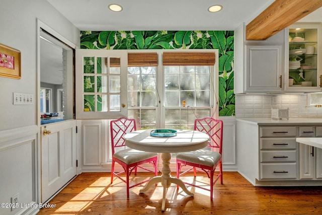 dining area with light wood finished floors, wainscoting, and recessed lighting