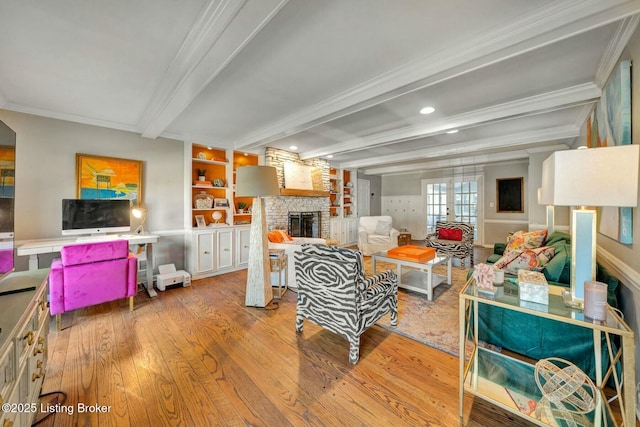 living room with a large fireplace, crown molding, beamed ceiling, and wood finished floors