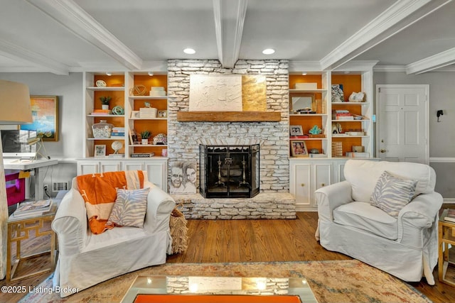 living area featuring built in features, beam ceiling, a fireplace, ornamental molding, and wood finished floors