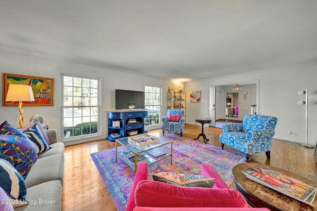 living room featuring ornamental molding, wood finished floors, and baseboards