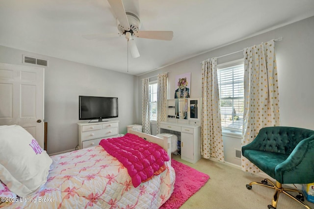 bedroom with light colored carpet, visible vents, ceiling fan, and multiple windows