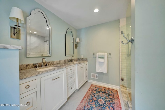 full bathroom featuring double vanity, a shower stall, visible vents, and a sink