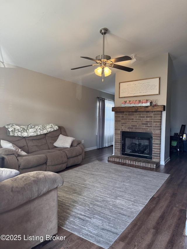 living area featuring vaulted ceiling, a brick fireplace, dark wood finished floors, and baseboards