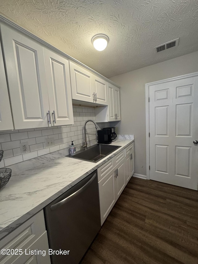 kitchen with dark wood-style floors, a sink, visible vents, white cabinets, and dishwasher