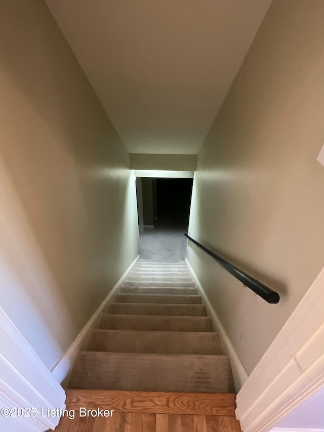 staircase with baseboards and wood finished floors