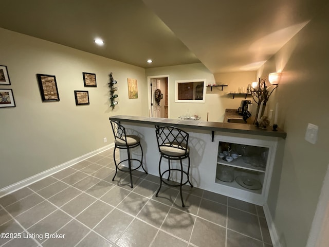 bar featuring recessed lighting, baseboards, indoor wet bar, and tile patterned floors