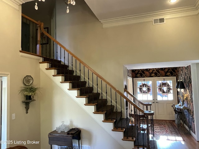 stairs featuring ornamental molding, french doors, a high ceiling, and visible vents