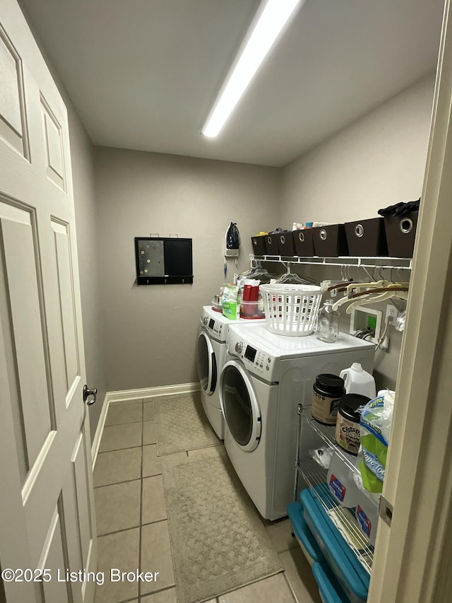 laundry area featuring washer and dryer, laundry area, baseboards, and light tile patterned floors