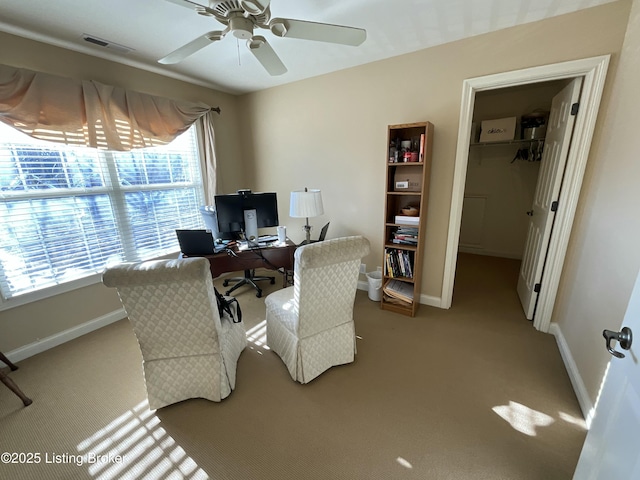 office space featuring carpet floors, baseboards, visible vents, and ceiling fan