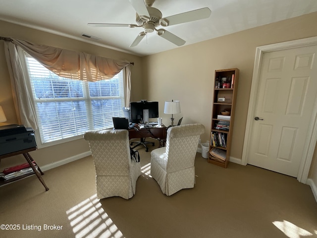 carpeted office space with ceiling fan, visible vents, and baseboards