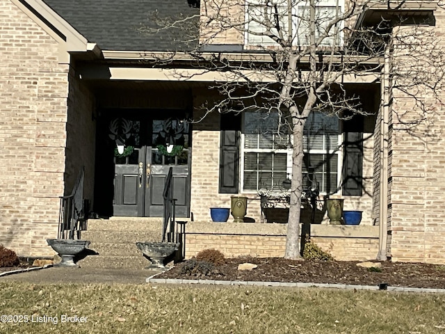 entrance to property featuring brick siding and french doors