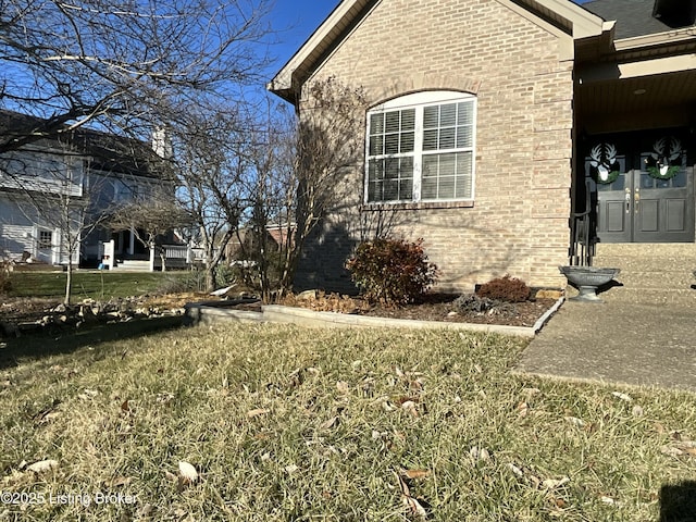 view of property exterior featuring brick siding and a lawn