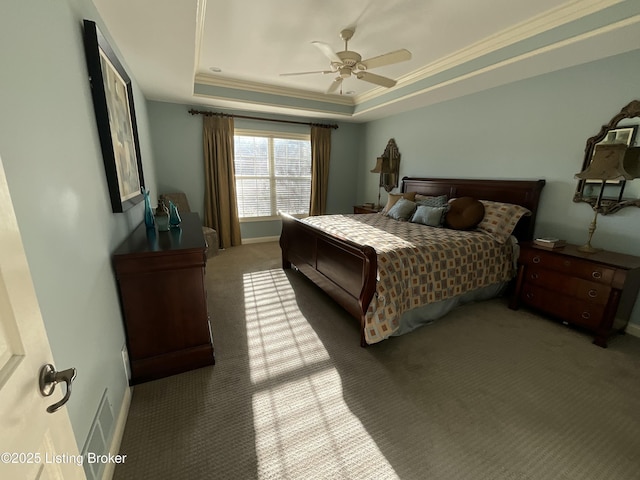 carpeted bedroom featuring baseboards, a tray ceiling, a ceiling fan, and crown molding