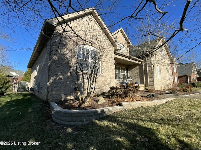 view of home's exterior featuring a yard and brick siding