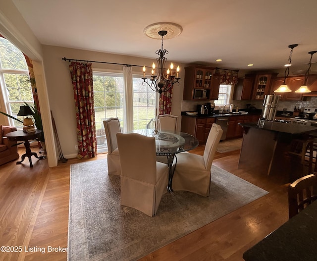 dining space with recessed lighting, light wood-style flooring, and an inviting chandelier