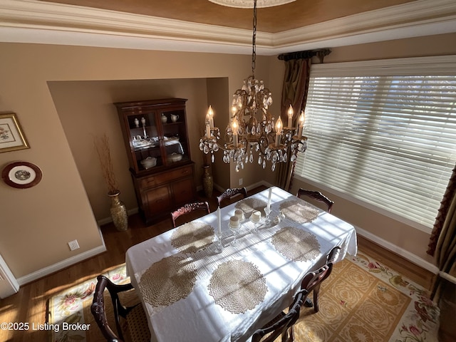 dining space with baseboards, wood finished floors, and an inviting chandelier