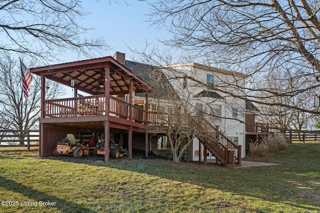 rear view of property with stairway, a chimney, a yard, and fence