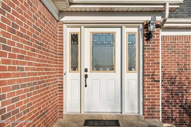 doorway to property featuring brick siding