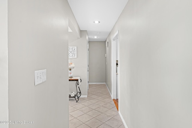 corridor featuring light tile patterned flooring and baseboards