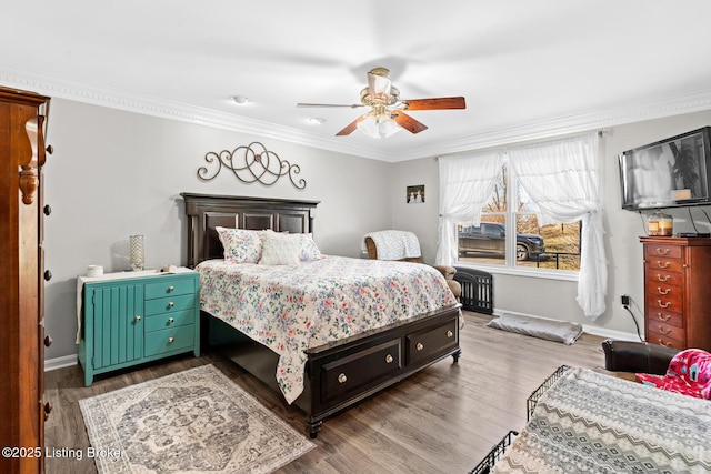 bedroom featuring ornamental molding, a ceiling fan, baseboards, and wood finished floors