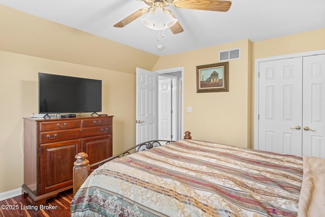 bedroom with visible vents, a ceiling fan, dark wood finished floors, a closet, and vaulted ceiling