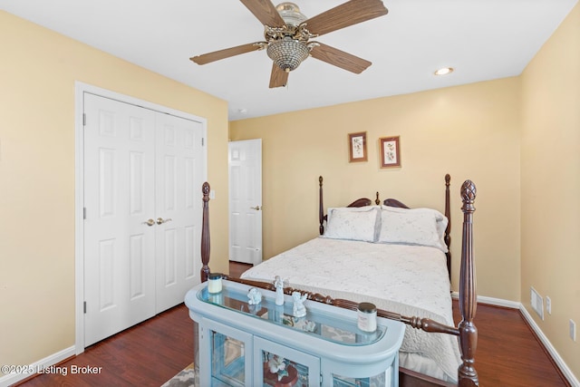 bedroom with a ceiling fan, dark wood-style floors, baseboards, and a closet