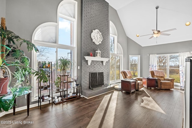 living area with a brick fireplace, high vaulted ceiling, ceiling fan, and wood finished floors