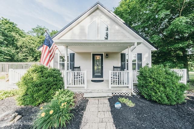 bungalow featuring fence and a porch