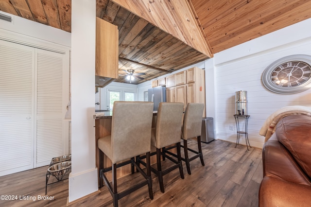 dining space with a dry bar, wooden ceiling, dark wood finished floors, and a ceiling fan