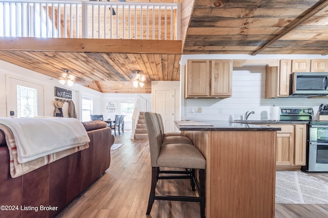 kitchen with wooden ceiling, light wood-style flooring, appliances with stainless steel finishes, light brown cabinetry, and dark countertops