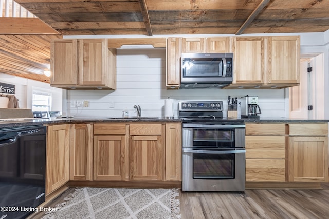 kitchen with light wood finished floors, wooden ceiling, appliances with stainless steel finishes, light brown cabinets, and a sink