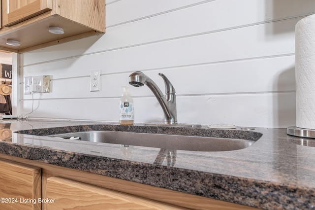 interior details with dark stone counters and a sink