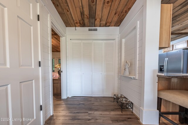 corridor with dark wood-style floors, wood ceiling, and visible vents