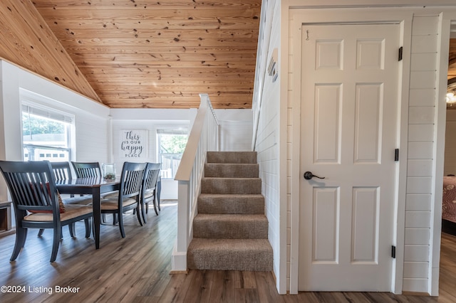 stairway featuring wood ceiling, a healthy amount of sunlight, vaulted ceiling, and wood finished floors