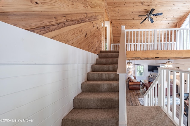 stairs with a ceiling fan and wood ceiling