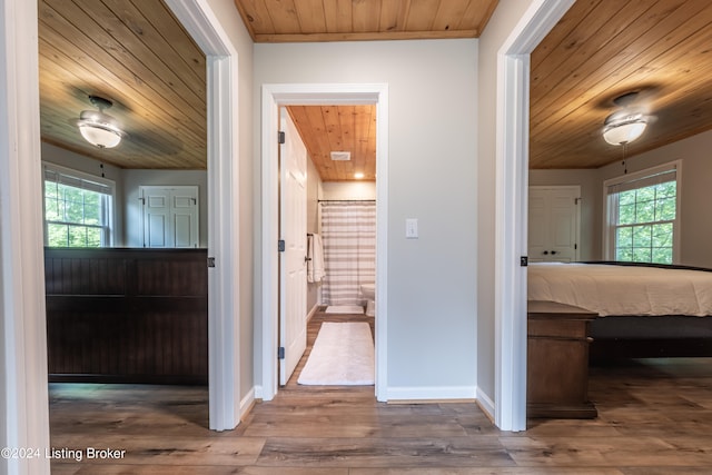 hall with a wealth of natural light, wooden ceiling, and wood finished floors