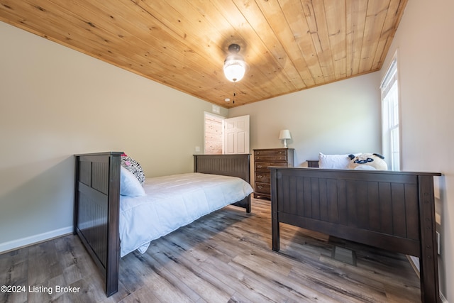 bedroom featuring wood ceiling, baseboards, and wood finished floors