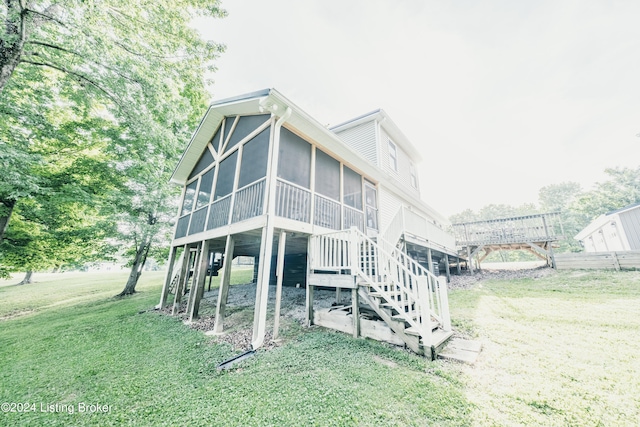 back of property with a yard, stairway, and a sunroom