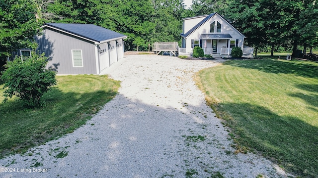 view of front facade with a porch, a front yard, gravel driveway, and a garage